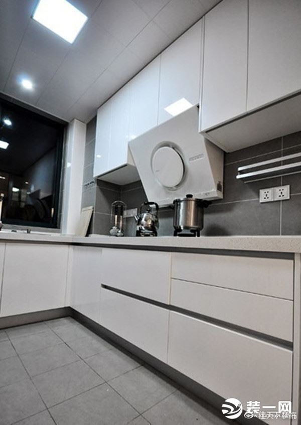 ?白色烤瓷橱柜搭配灰色瓷砖，展露出低调的时尚风范。