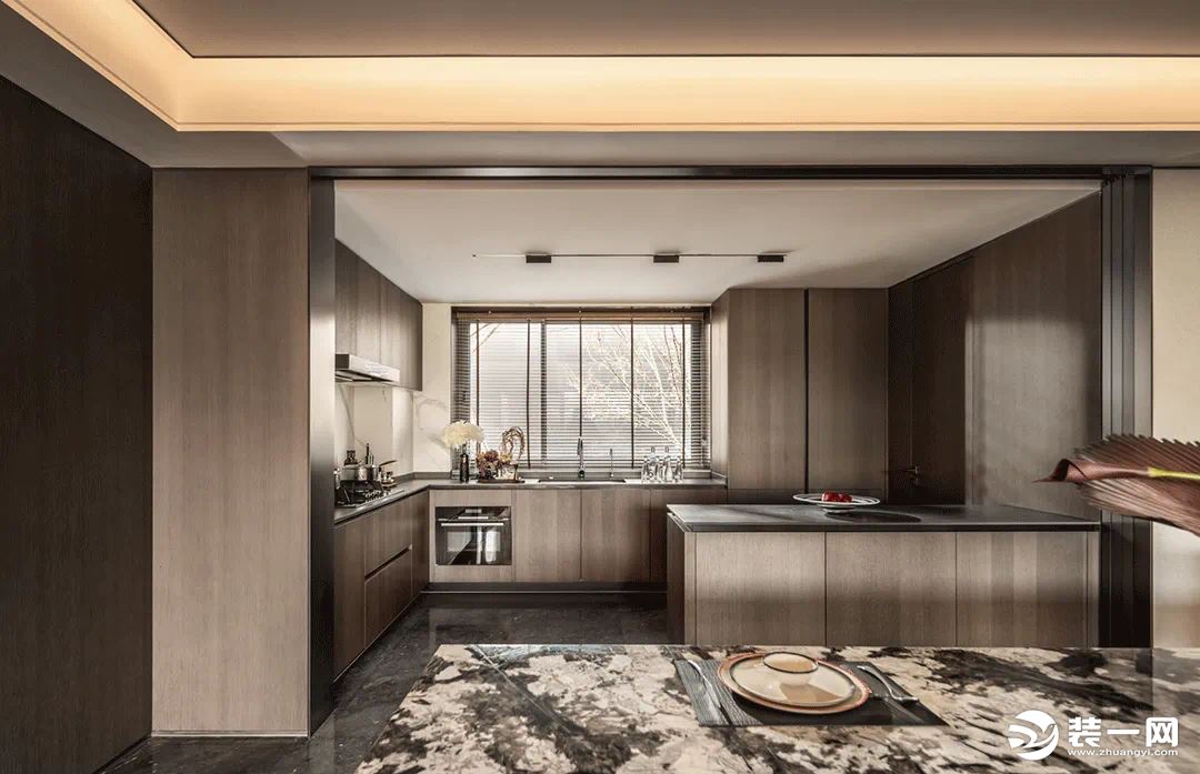厨房一改白灰的设计，大面积采用了棕木色作为墙壁装饰，加工台和橱柜同样是棕色的原木纹理
