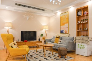 实木家具和黄色沙发，让客厅温暖如许。三脚落地，非常有线条感，电视左右放上两台，看起来富有节奏。