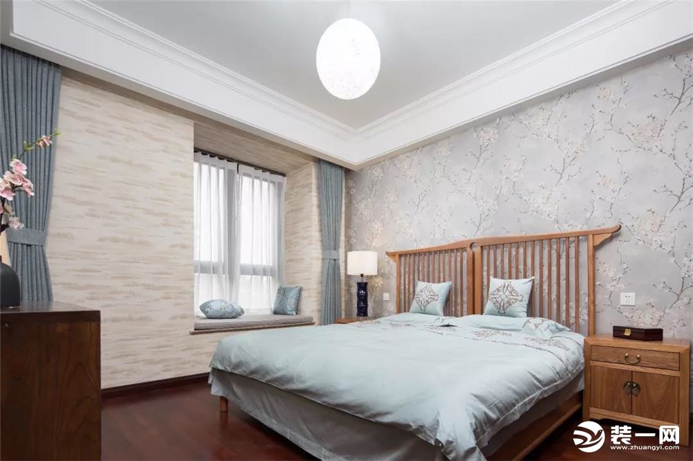 卧室墙面贴上米白带纹理的壁布，结合上儒雅壁布张贴的床头背景墙，还有一套原木质感的床与床头柜，结合上禅