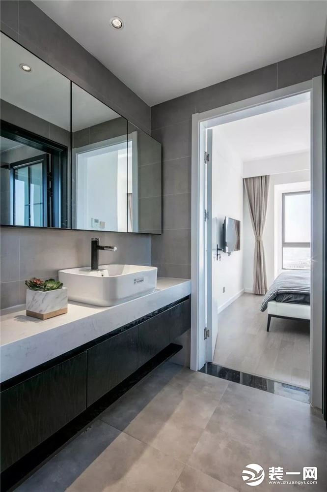 卫生间干区以灰色简约的空间基调，白色的洗手盆充满了优雅的质感，大面积的镜柜实用相当。
