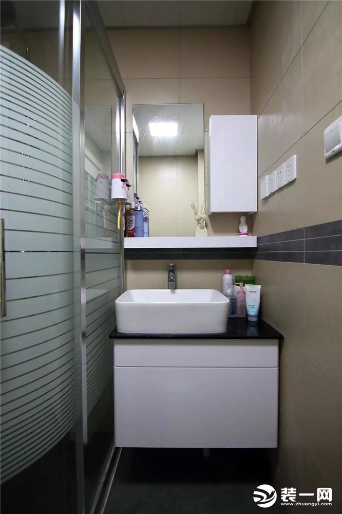 ▲紧凑的卫浴空间，除了墙面的收纳，淋浴房的玻璃也被利用起来，一人的洗漱也很实用方便。