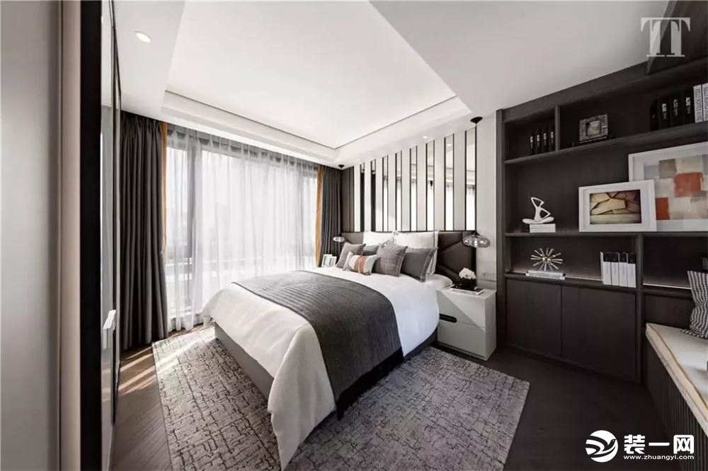 ▲现代庄重的卧室，地面一款灰色的地毯，干净优雅的床单，深色的书架，带给人的是一个稳重舒适的卧室空间。