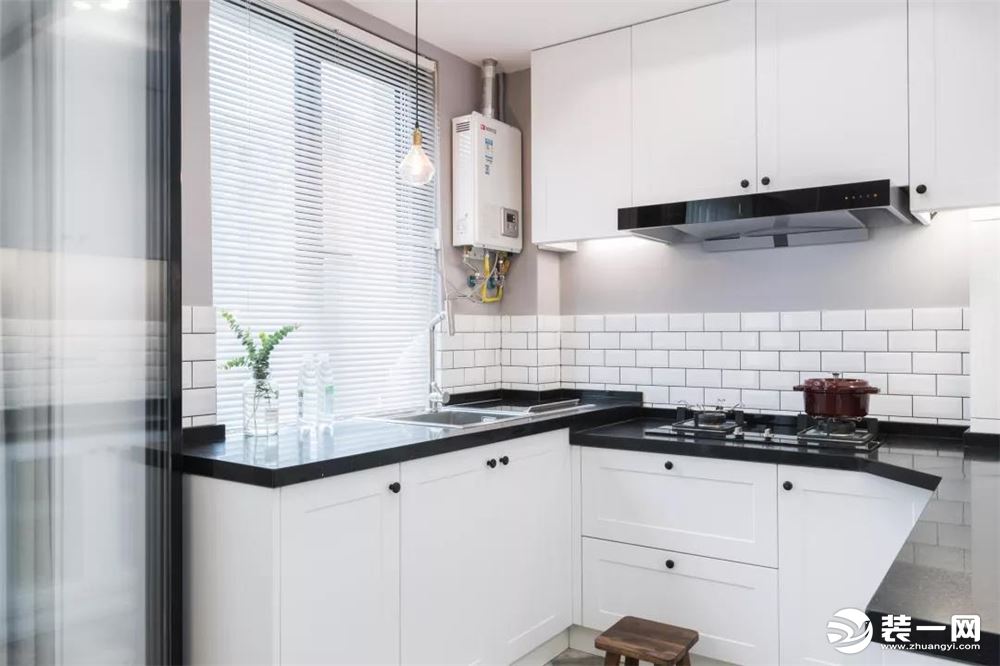 因为户型和空间的原因，厨房设计成了半包围的形式，呈U字型，黑色的大理石台面和白色的橱柜是经典搭配，清