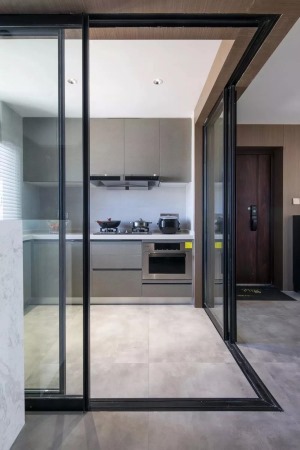 厨房以玻璃做隔墙，打开玻璃推门后就成为一个开放的空间，宽敞大方。