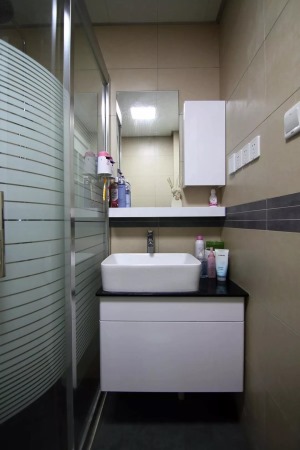 ▲紧凑的卫浴空间，除了墙面的收纳，淋浴房的玻璃也被利用起来，一人的洗漱也很实用方便。