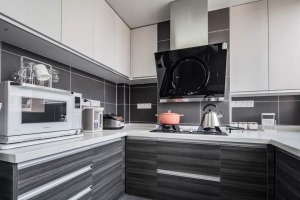 ▲U型的黑白灰厨房布局，以灰色带有纹理的橱柜门板，结合灰色墙面亚光砖，白色吊柜与黑色油烟机，时尚大方