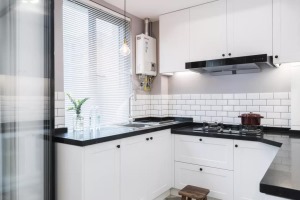 因为户型和空间的原因，厨房设计成了半包围的形式，呈U字型，黑色的大理石台面和白色的橱柜是经典搭配，清