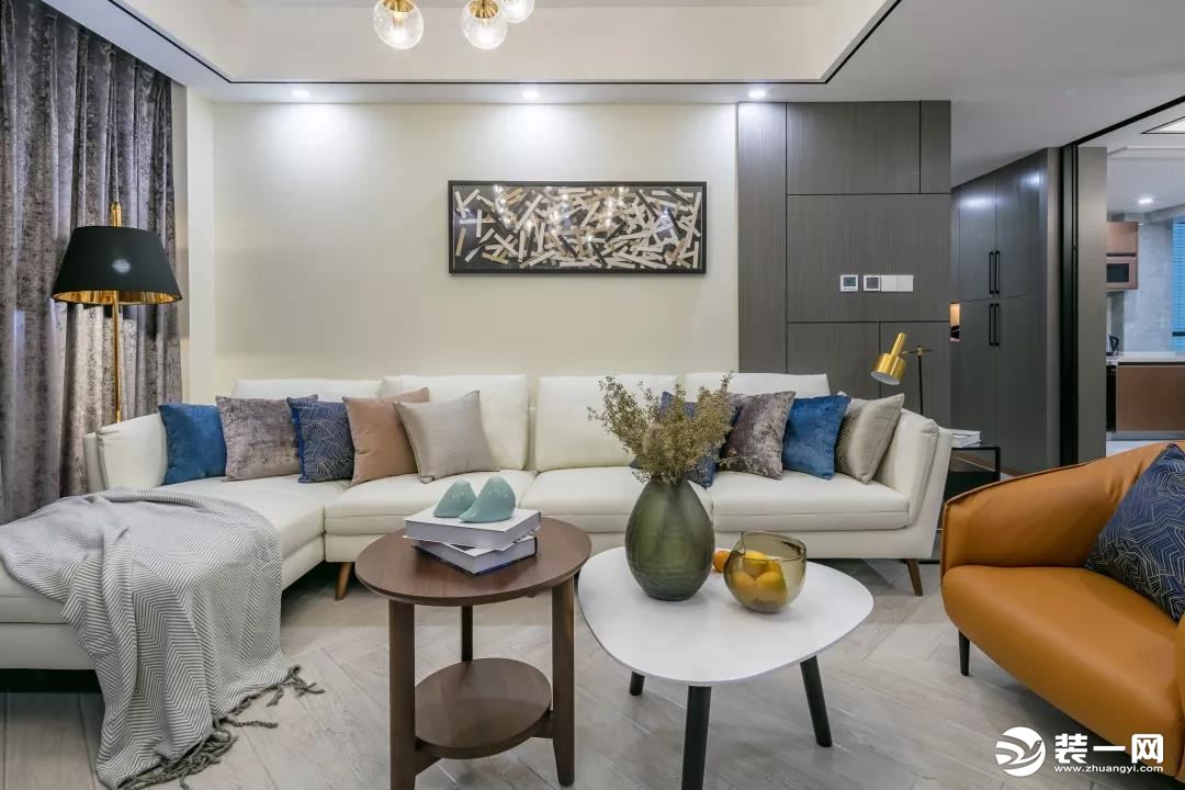 客厅整体现代大方的空间基调，在舒适的沙发搭配稳重气质的家居，混入橙色皮质休闲沙发，带来的是轻松成熟的