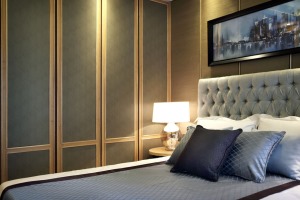 卧室：保持与客厅一致的格调搭配，天然木纹饰面与麻灰墙纸色彩协调，浅灰的床品装饰质感极佳，飘窗的改造让