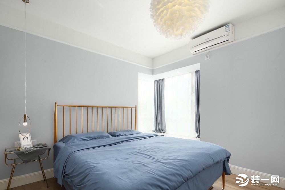 浅灰色的墙壁与原木色的地板、床相结合构成简单舒适的房间，蓝色的棉麻床单很适合夏天，巨大的飘窗带来良好