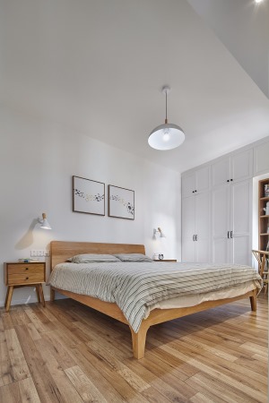 床头背景墙对称的装饰画与床头壁灯，还有原木质感的小床头柜，为这个简洁的卧室带来了几分自然与温馨的气息