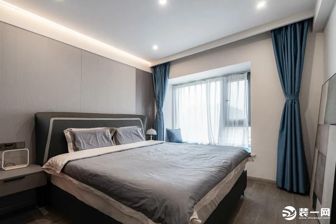 卧室以绅士灰为主色调，搭配优雅蓝色软饰，锻造出一个低调内敛的睡眠环境。