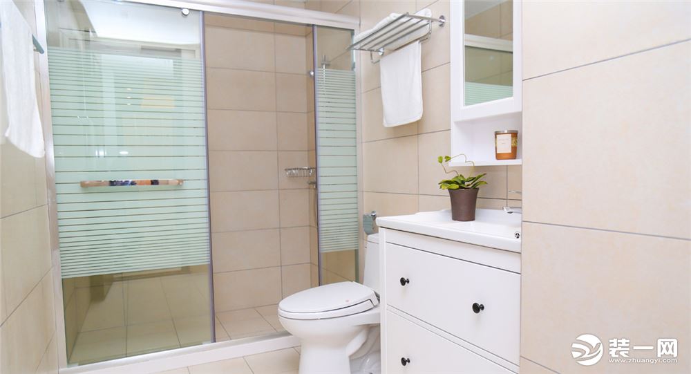 卫生间整体铺贴浅色瓷砖，造型线条勾勒处腰线位置，玻璃淋浴房尽量让空间做干湿分区。