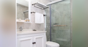 卫生间地面通铺灰色大理石地砖，搭配白色的家具与卫浴，简洁干净，干湿分离的设计提高使用效率。