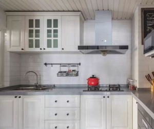 厨房地面黑白瓷砖交叠，墙砖工字铺贴，白色橱柜搭配灰色台面，右侧墙面取消吊柜，直接安置厨电。