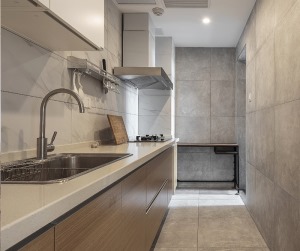 厨房延续整个空间木色灰色的搭配，木色橱柜、浅灰色的地砖搭配哑光爵士白墙砖。