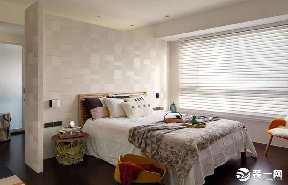 床头的白色背景墙，错落有致的方块纹理，让整个卧室富有层次感，阳光通过白色的百叶窗照射进来，使得整个卧