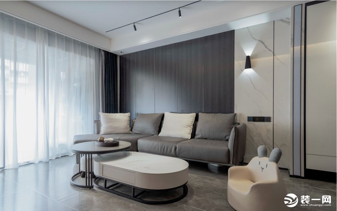 灰色沙发配上木饰面的沙发背景，黑色、白色和灰色交织其中，室内灯光的选用和室外的采光相结合，氛围舒适，