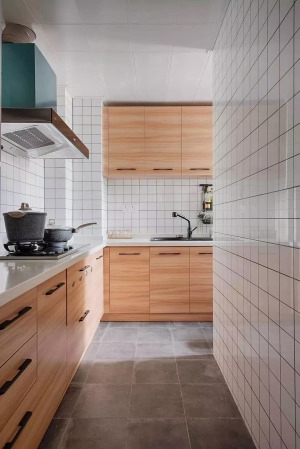 厨房地面选用的是水泥灰地砖，不仅耐脏防滑，方便清理，而且看起来也很有质感。原木橱柜搭配白色小方砖，让