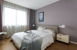 主卧室的床头背景墙被刷成了淡紫色，窗帘也加入了一些紫色，让卧室看起来更加高贵典雅一些。床尾的地方摆放