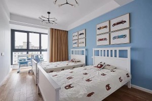 儿童房内摆放了两张同样的单人床，床的上方也是对称的挂画，天蓝色的背景墙搭配橘黄色的窗帘，让儿童房显得