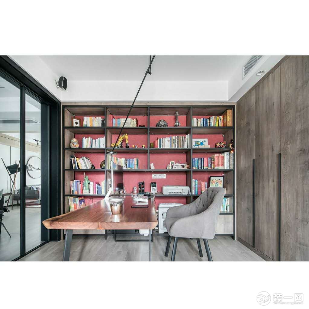 位于北侧的舒服，敞开式的大书架能容纳夫妇二人的部分常看书籍。红色的壁纸延续了其他空间的红色元素。