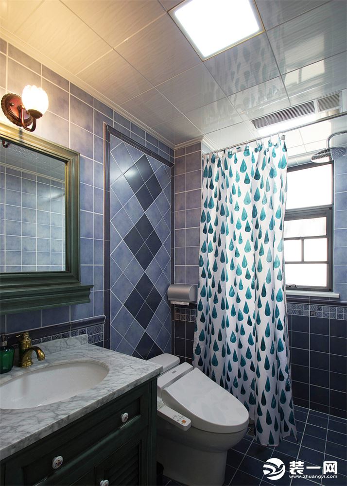 卫生间墙面地中海色调的蓝色瓷砖斜铺，搭配上美式风格的孔雀墨绿，连卫生间都很有质感