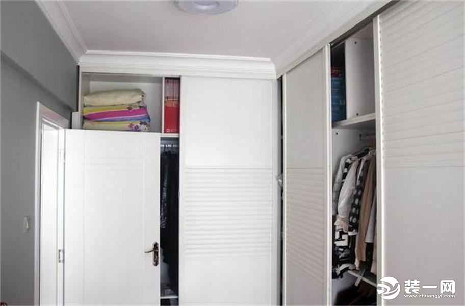衣帽间和主卧是连着在一起的，一侧是衣柜，另一侧摆上了小书柜，也是一个小书房了。