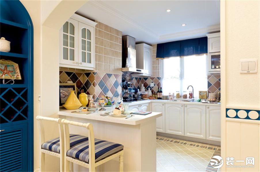 厨房空间明亮，白色橱柜，色彩各异的墙面砖块蓝色窗帘，为厨房增添了雅致，另外厨房的地方也设计了一处吧台