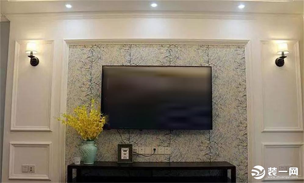 电视墙用石膏板+石膏线做装饰，中间的背景部分贴的是彩纹壁纸，简单的黑色电视柜摆在那也觉得很温馨。