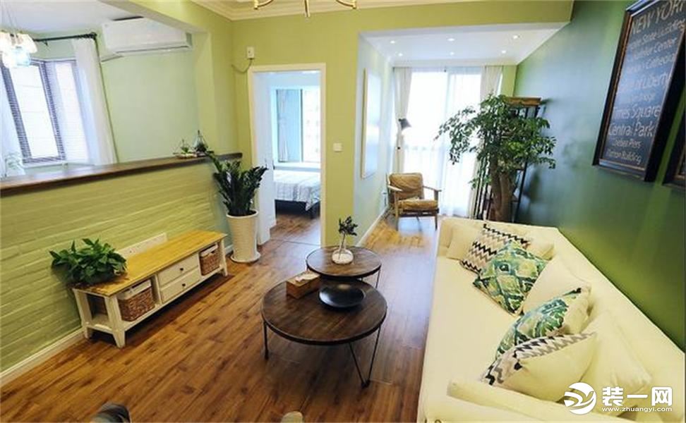 地面整体铺设的木地板，客厅和休闲室中间的墙面打开，做成半墙，吧台可以置物，墙面刷成浅浅的草绿色