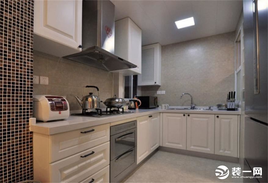 厨房的灯光并不强烈，而白色的L形橱柜正好提高了整个空间的明亮度，又透露出时尚的元素