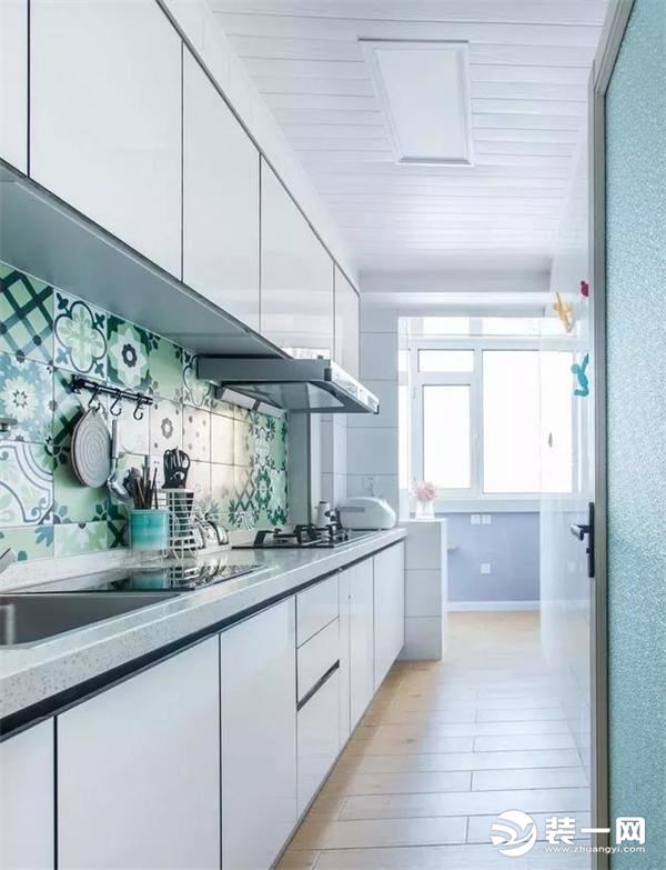 厨房是一个小长条的空间，带着的阳台也是生活型的。一字型的白色橱柜搭配绿色时尚小花砖，光照进来好 清新