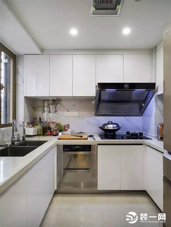 厨房装的是白色的U型橱柜，为了让整体风格看着更融合一些，墙面选的瓷砖都是大理石纹，