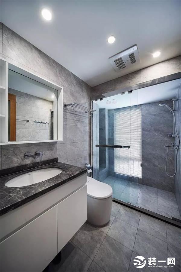 卫生间和客厅的风格一样，大理石纹的灰色墙地砖，黑色的大理石洗漱台面，安装玻璃隔断做干湿分离效果