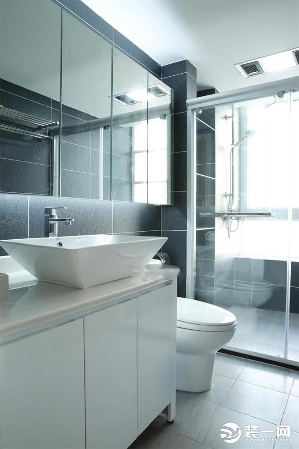 卫生间安装了玻璃推拉门做成干湿分离效果，墙面地面瓷砖和厨房一样，也是黑色和灰色的搭配
