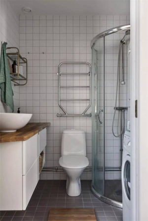 卫生间空间不大，独立的淋浴间，洗衣机放置在卫生间也不受影响，地面灰色的小方砖搭配白色的墙面瓷砖，时尚