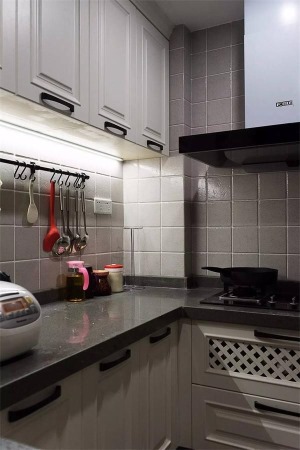厨房还是比较紧凑的，墙面采用灰白色的小方砖，更显时尚精致。