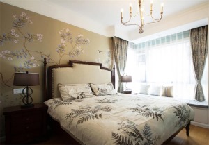 主卧美式的实木床和床头柜，咖色大气花纹的壁纸让这个卧房清新雅致，彰显大气