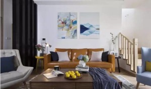 卡其色的皮沙发和灰色、蓝色布艺的单人座椅，很有北欧的休闲情调，装饰画和抱枕色彩丰富让空间氛围都活跃了