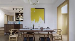 餐边柜和吧台相连，墙面装饰一幅黄色的抽象画作，餐厅的背景墙也如此有情调
