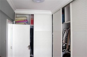 衣帽间和主卧是连着在一起的，一侧是衣柜，另一侧摆上了小书柜，也是一个小书房了。