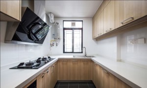 厨房依然是原木双饰面的整体橱柜，收纳空间非常多，各种材料，碗盘都能分类摆放，整洁大方。