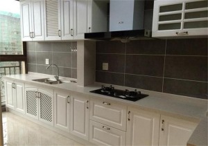 厨房长方形空间，带着的阳台都一起打通，墙面灰色的瓷砖搭配白色的整体橱柜，很亮。
