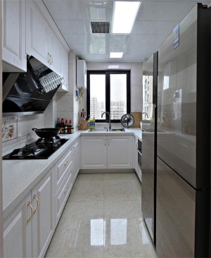 厨房是长条形的空间，打造U型整体橱柜，留出来放双开门冰箱的位置。