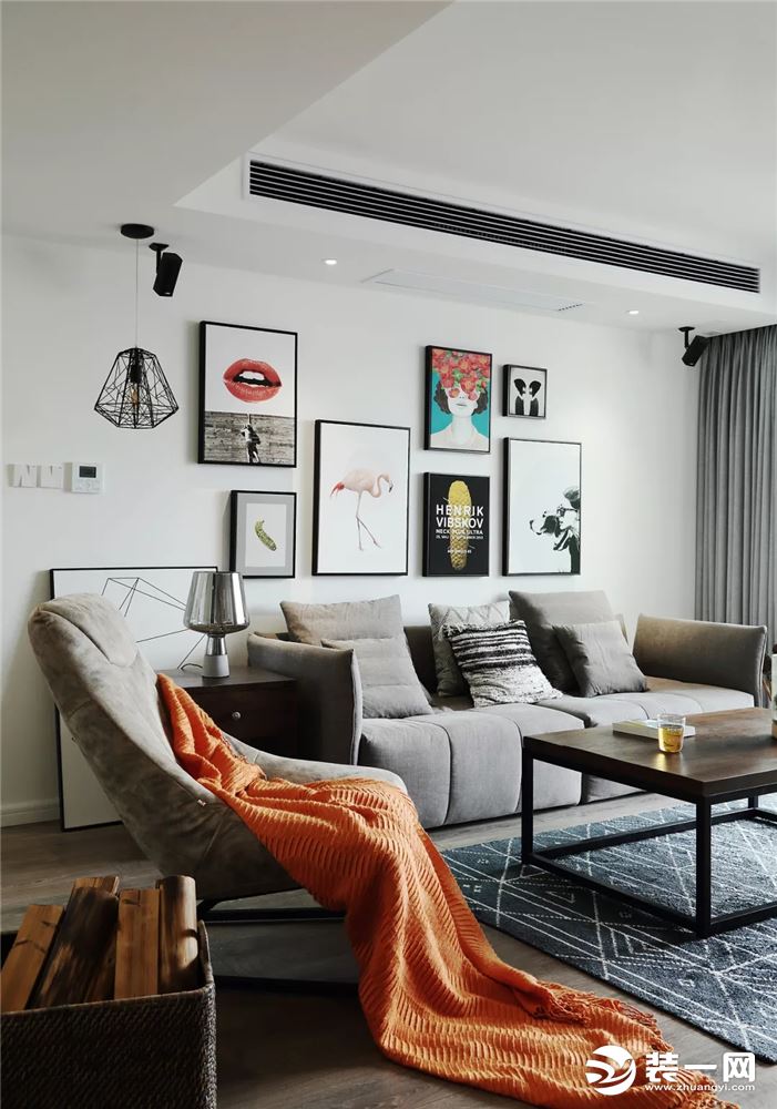 整个客厅的风格比较理性，单人沙发上的橙色沙发巾增添了一丝活泼的感觉。