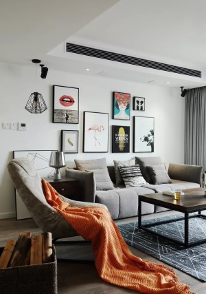 整个客厅的风格比较理性，单人沙发上的橙色沙发巾增添了一丝活泼的感觉。
