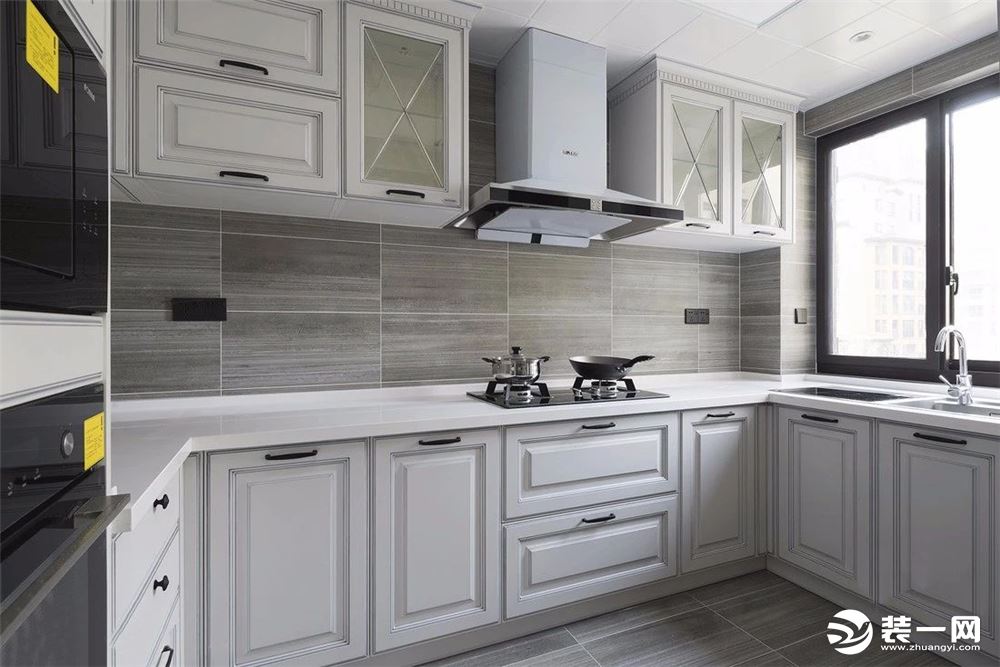 厨房依旧是定制柜子，白灰色明亮干净又不显单调，造型柜门更是被精心设计的最佳证明