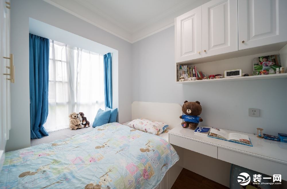 蓝色系的男孩房，做的是一体式的书柜设计，休憩区与学习区合二为一，美观又实用。
